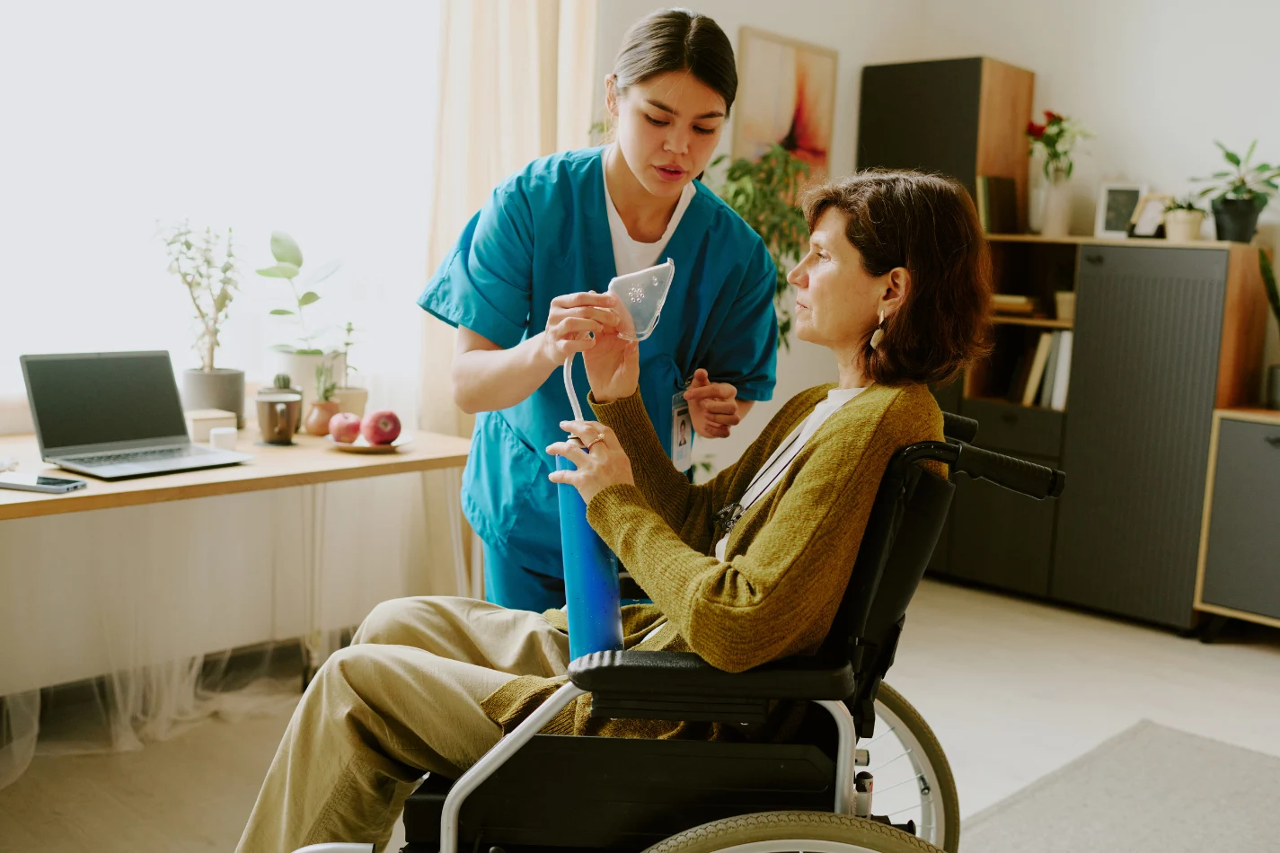 Nurse helping woman in wheelchair at home