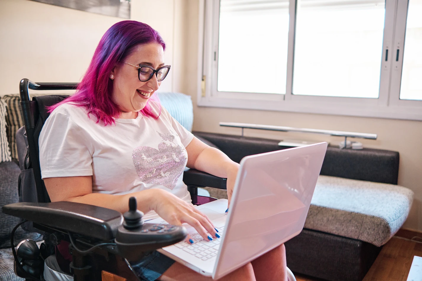 Disabled woman in wheelchair using laptop