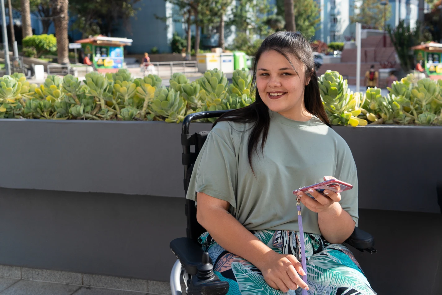 Disabled woman in wheelchair using mobile phone