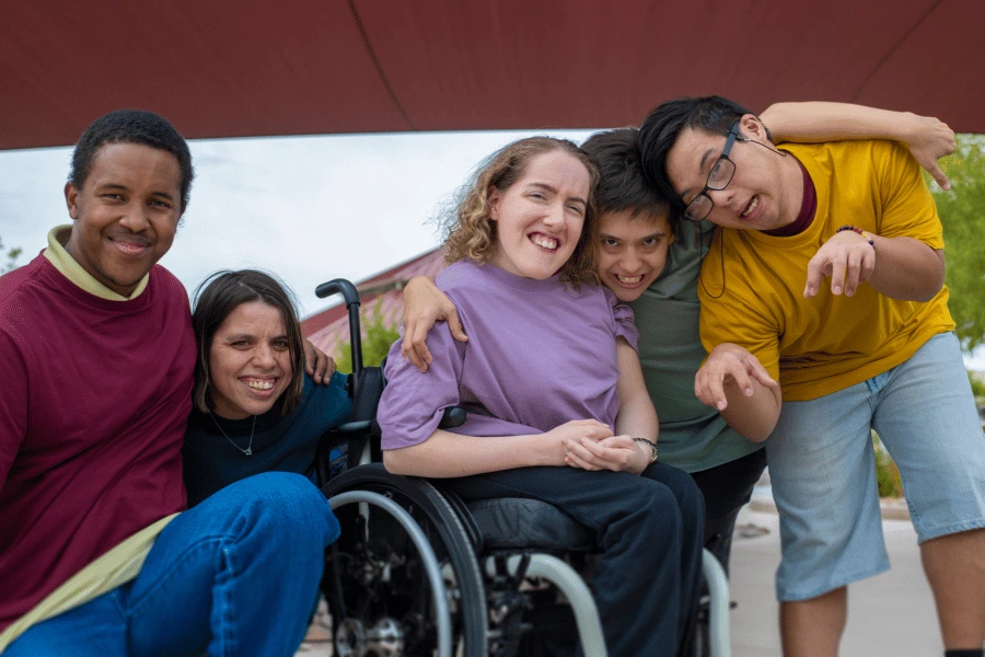Group of diverse disabled friends smiling at camera